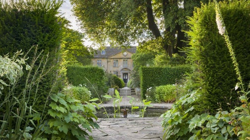 The front of the house at Tintinhull just visible through trees